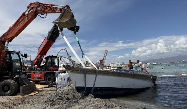 Ruspa Rimozione Barca3 Al Poetto escavatore in azione per rimuovere la barca arenata (sotto gli occhi dei bagnanti): il video
